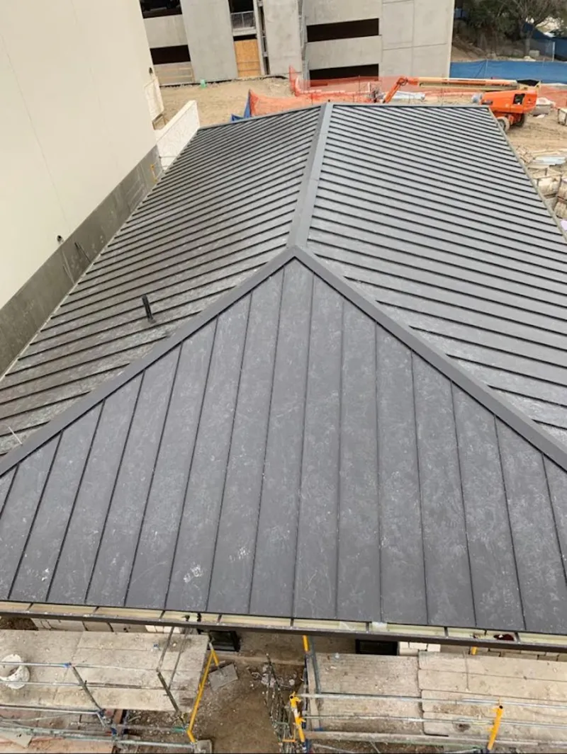 Commercial metal roof construction with crane equipment in Ulster